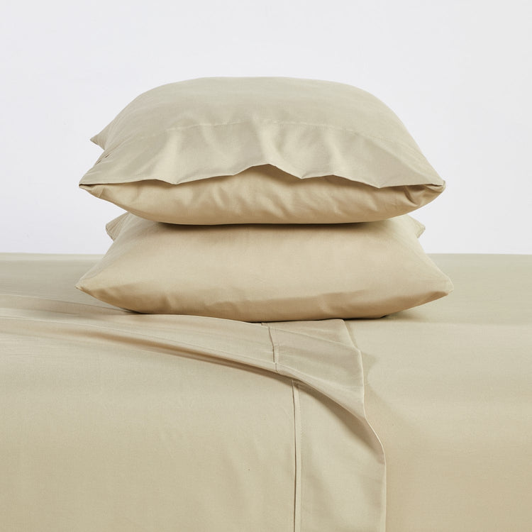 Beige bed sheets and pillows on a light background