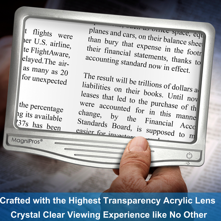 Hand holding a MagniPros magnifying device over text, with a blurred background