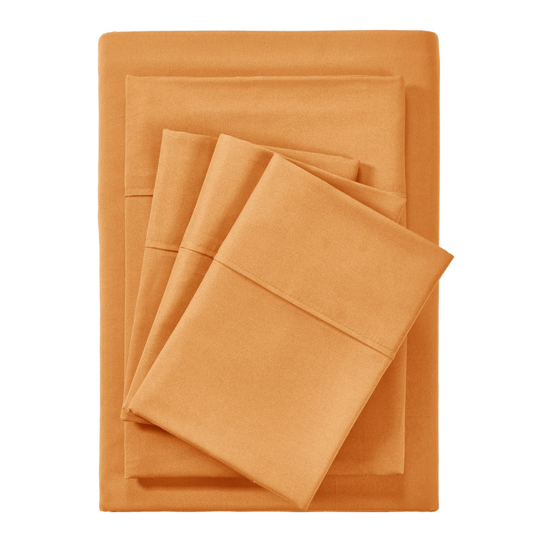 Orange bed sheets and pillowcases set on a white background