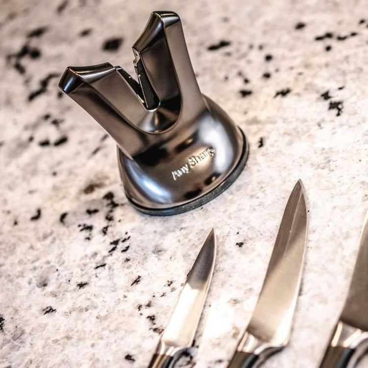 Knife sharpener with two knives on a speckled countertop
