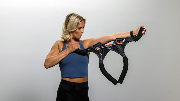 Woman exercising with a resistance band against a plain background