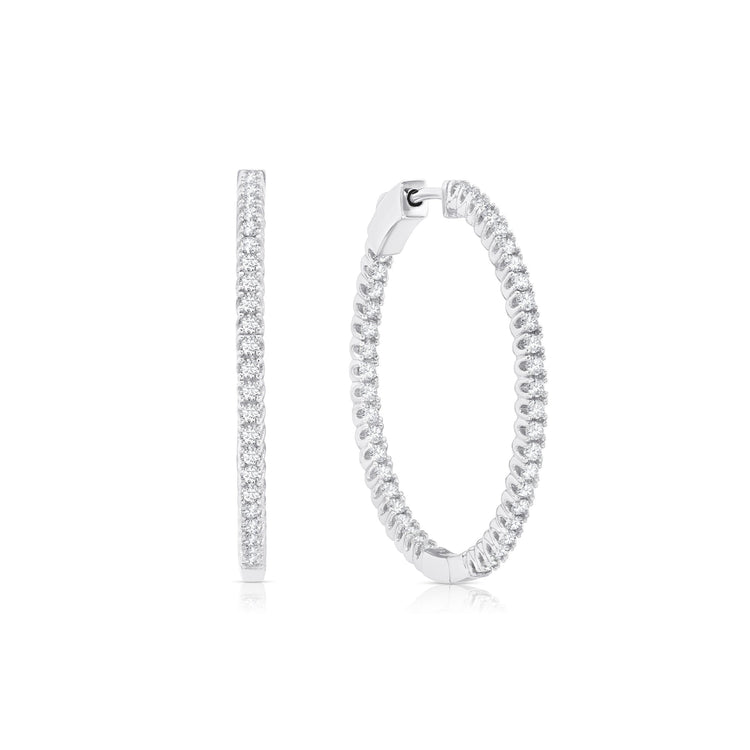 Silver hoop earrings with clear gemstones on a white background