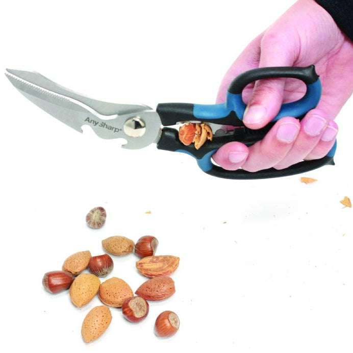Hand using a pair of kitchen shears to open nuts on a white background