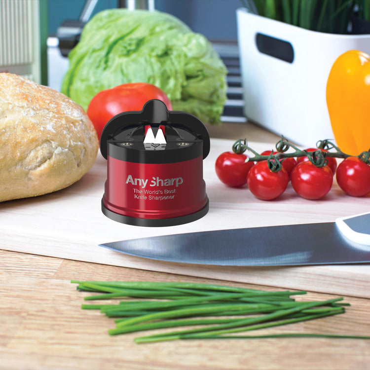 AnySharp knife sharpener on a kitchen counter with vegetables and bread