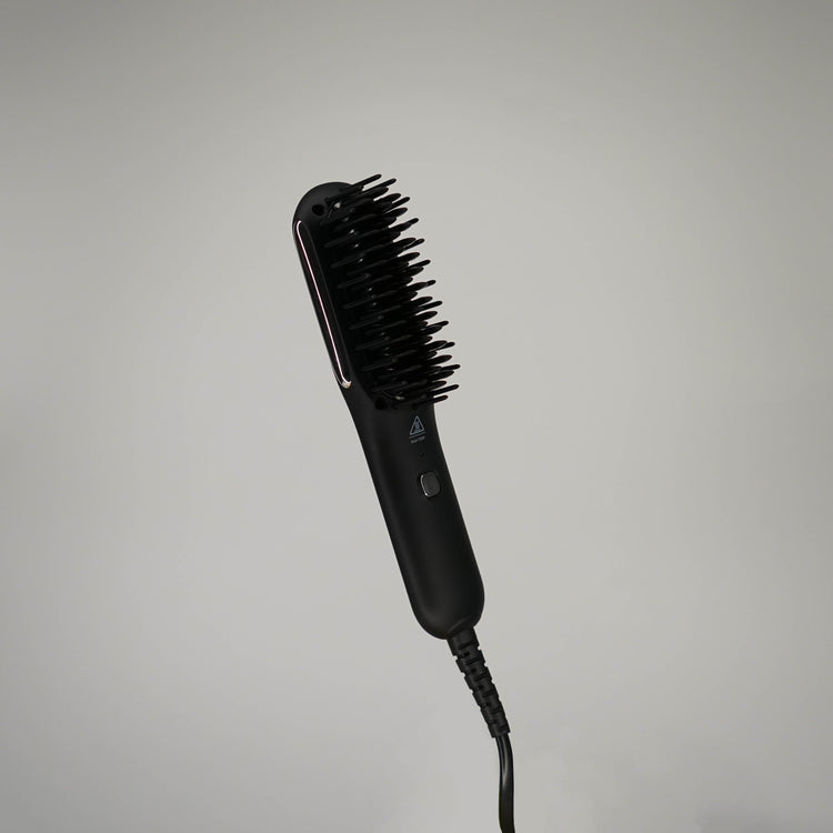 Black hairbrush with bristle head on a gray background