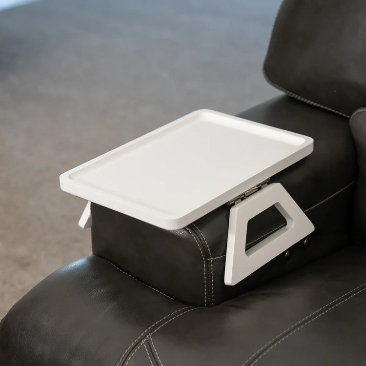 White lap desk attached to a black leather armchair