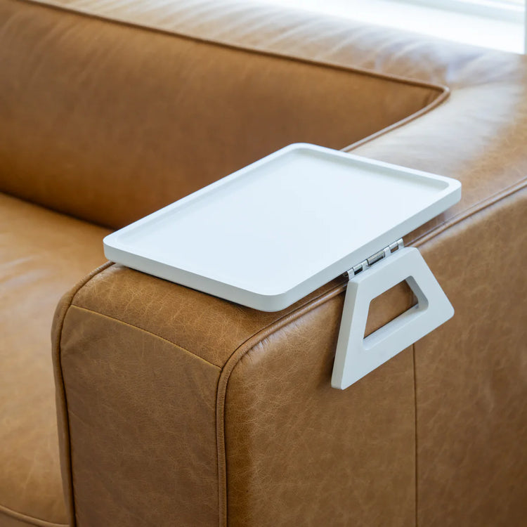 White tray attached to a brown leather couch