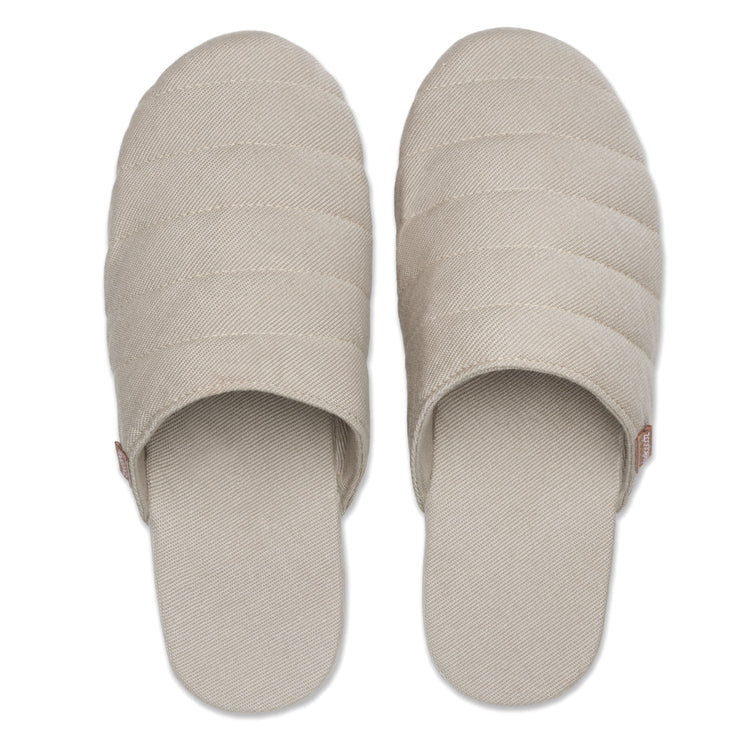Pair of beige slippers on a white background