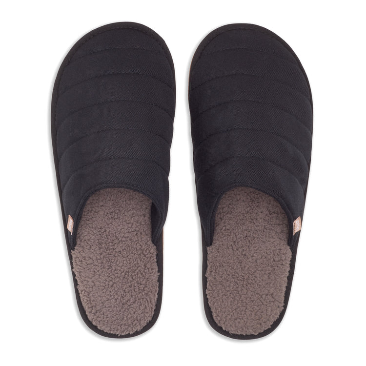 Pair of black slippers with a textured sole on a white background
