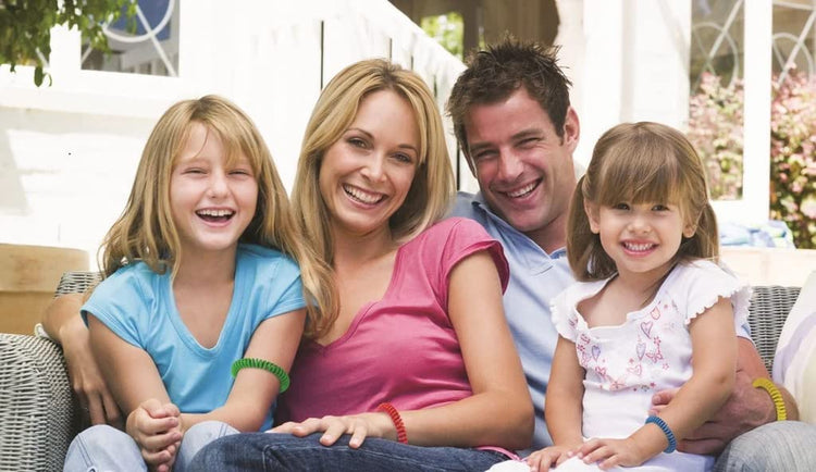 Family of four sitting together outdoors on a sunny day