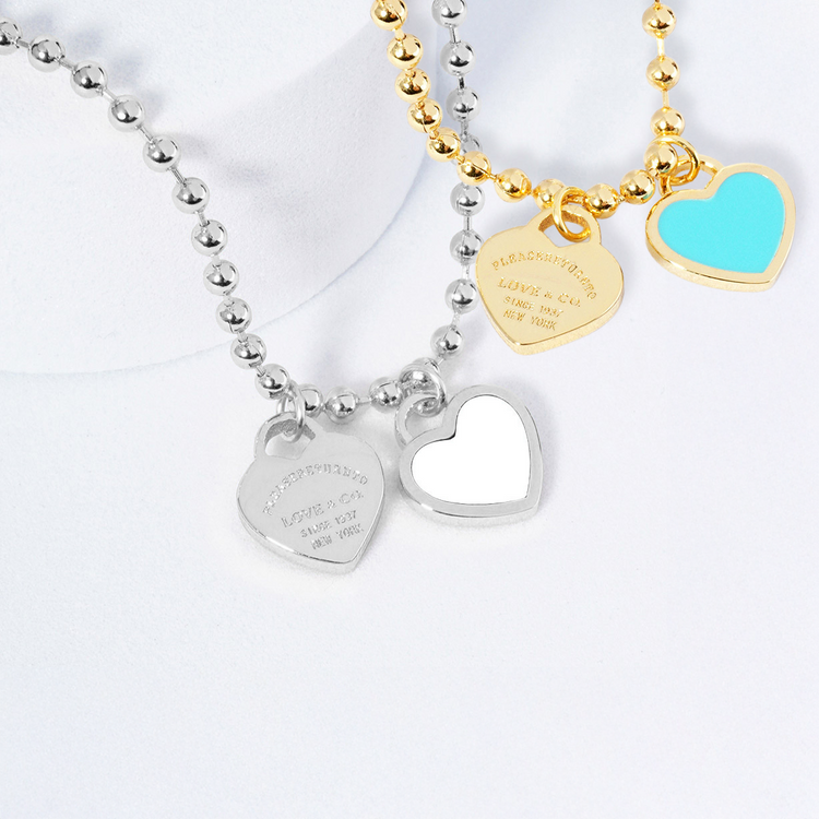 Two heart-shaped pendants on necklaces with a white background