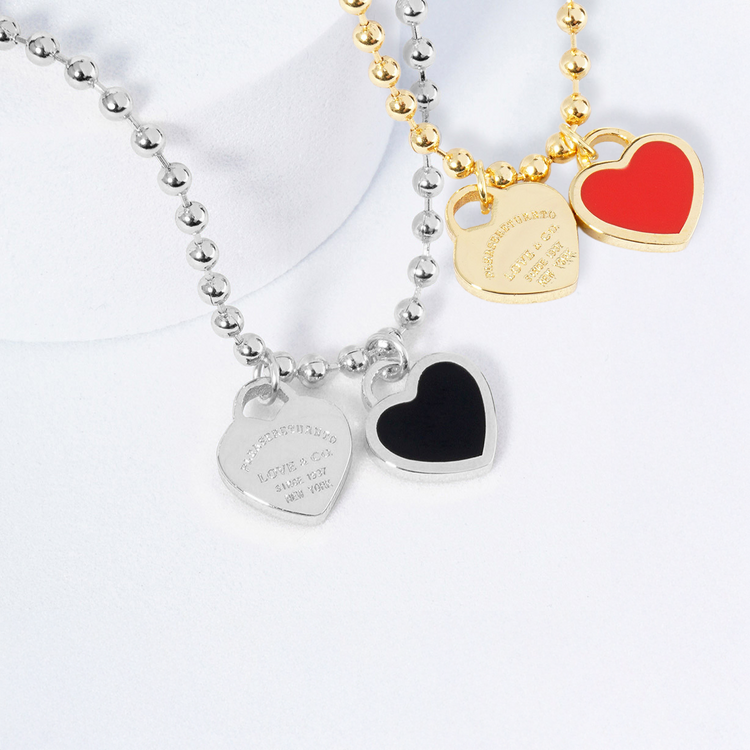Three heart-shaped pendant necklaces on a white background