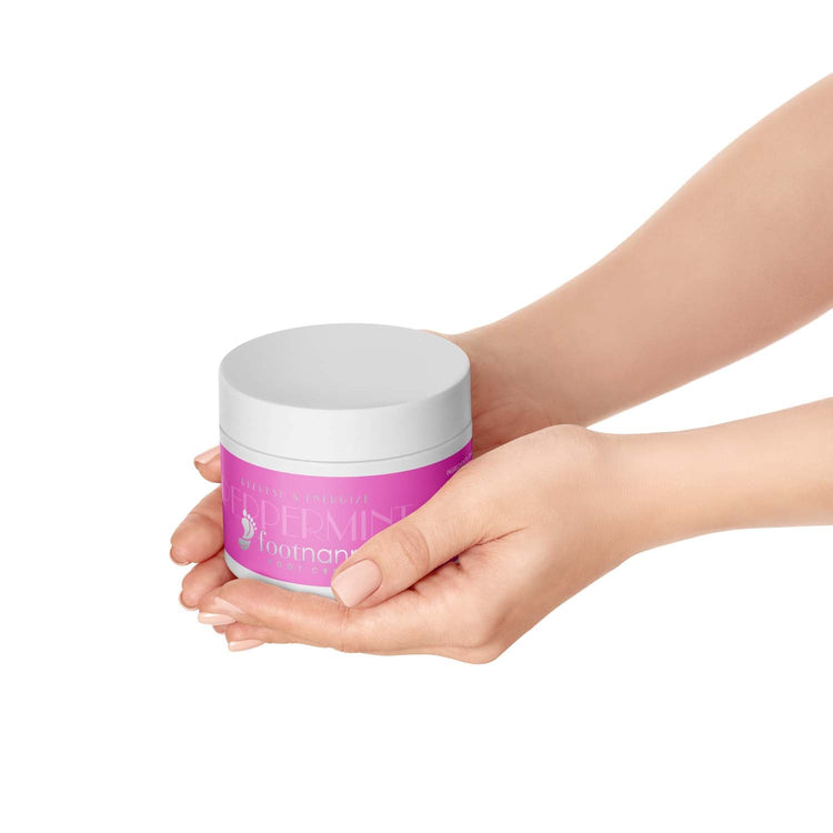 Hand holding a pink jar with a white lid on a white background