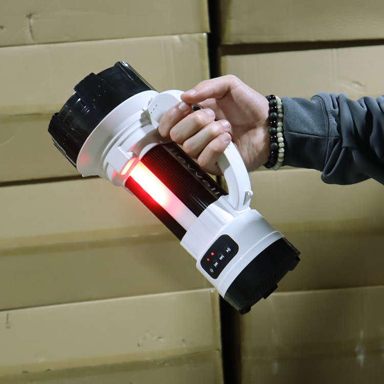 Person holding a large flashlight with a red light on a wooden background