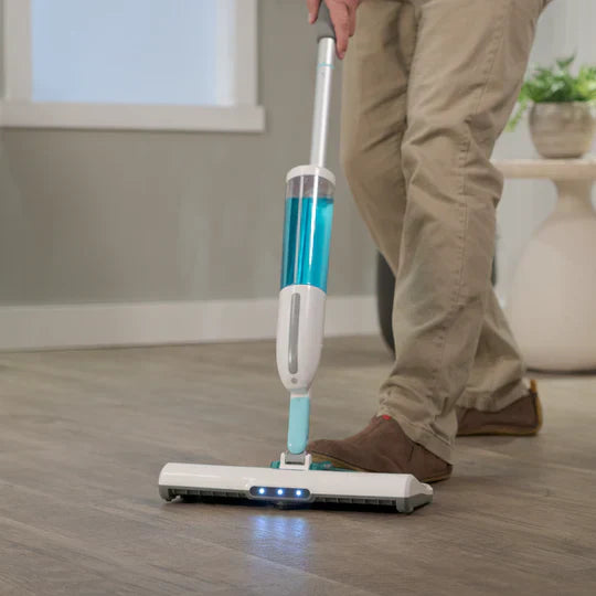 Person using a cordless vacuum cleaner on a wooden floor