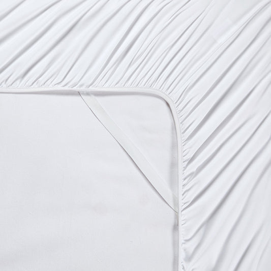 A white 6-piece bamboo sheet set on a bed, including a fitted sheet, flat sheet, and pillowcases, presented in a bright room setting with decorative plants and a nightstand.