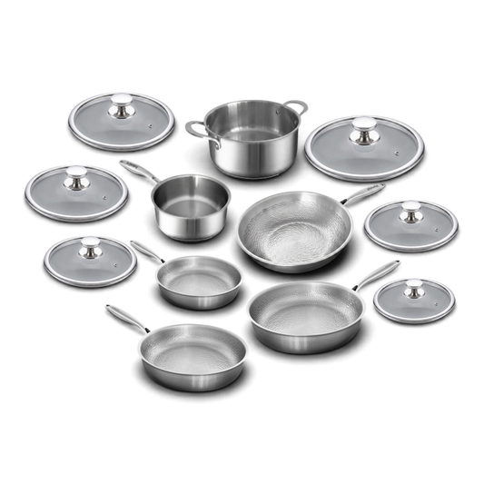 A stainless steel cookware set arranged on a white background, including multiple frying pans, a saucepan, a pot, and several glass lids with silver knobs.