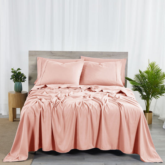 Pink bedding set on a bed with matching pillows in a bedroom setting.