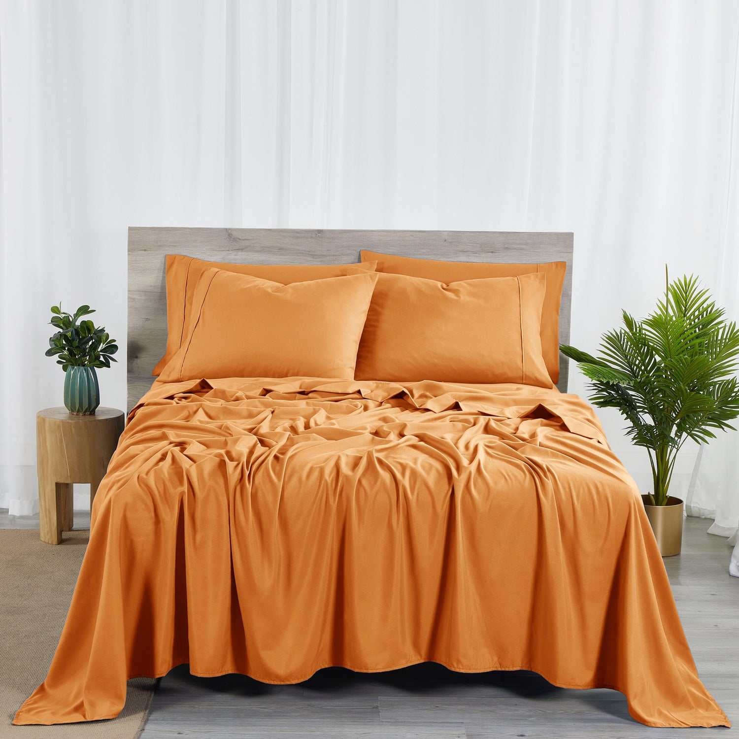 Orange bedding set on a bed with matching pillows in a bedroom setting.