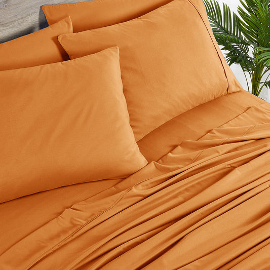 Orange bedding set on a bed with matching pillows in a bedroom setting.