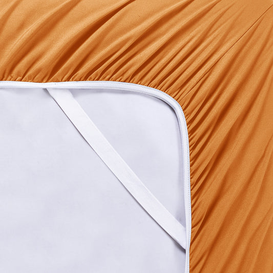 Orange bedding set on a bed with matching pillows in a bedroom setting.