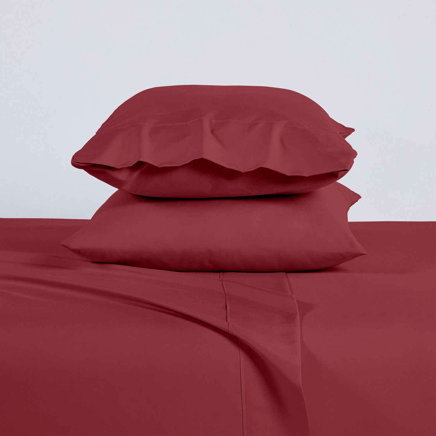 Red bed sheets and pillows on a white background