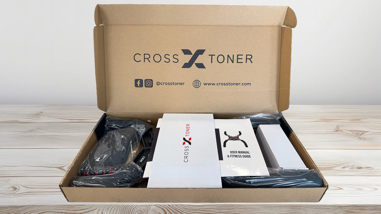 Open cardboard box containing Cross X Toner products on a wooden surface.
