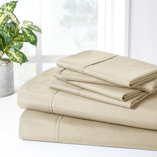A warm taupe colored 6-piece bamboo sheet set on a bed, with a flat sheet, fitted sheet, and pillowcases displayed. The bed is set against a room backdrop with a plant and nightstand on the side.