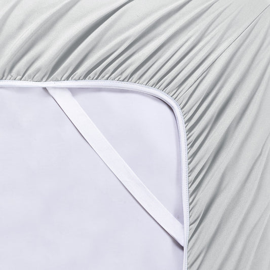 A silver 6-piece bamboo sheet set on a bed, including a fitted sheet, a flat sheet, and pillowcases, presented in a well-lit room with a plant and nightstand beside the bed.
