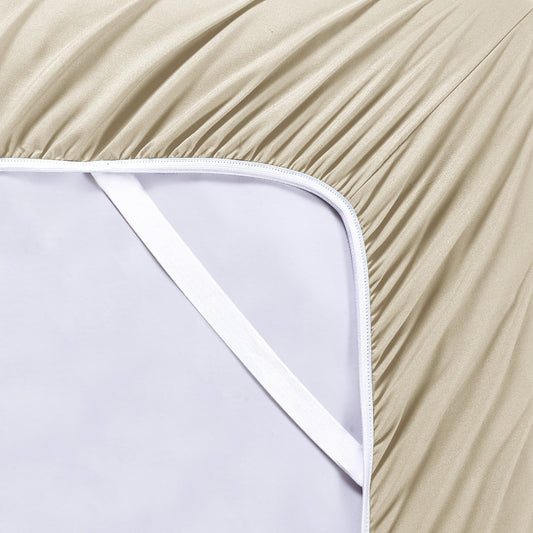 A warm taupe colored 6-piece bamboo sheet set on a bed, with a flat sheet, fitted sheet, and pillowcases displayed. The bed is set against a room backdrop with a plant and nightstand on the side.