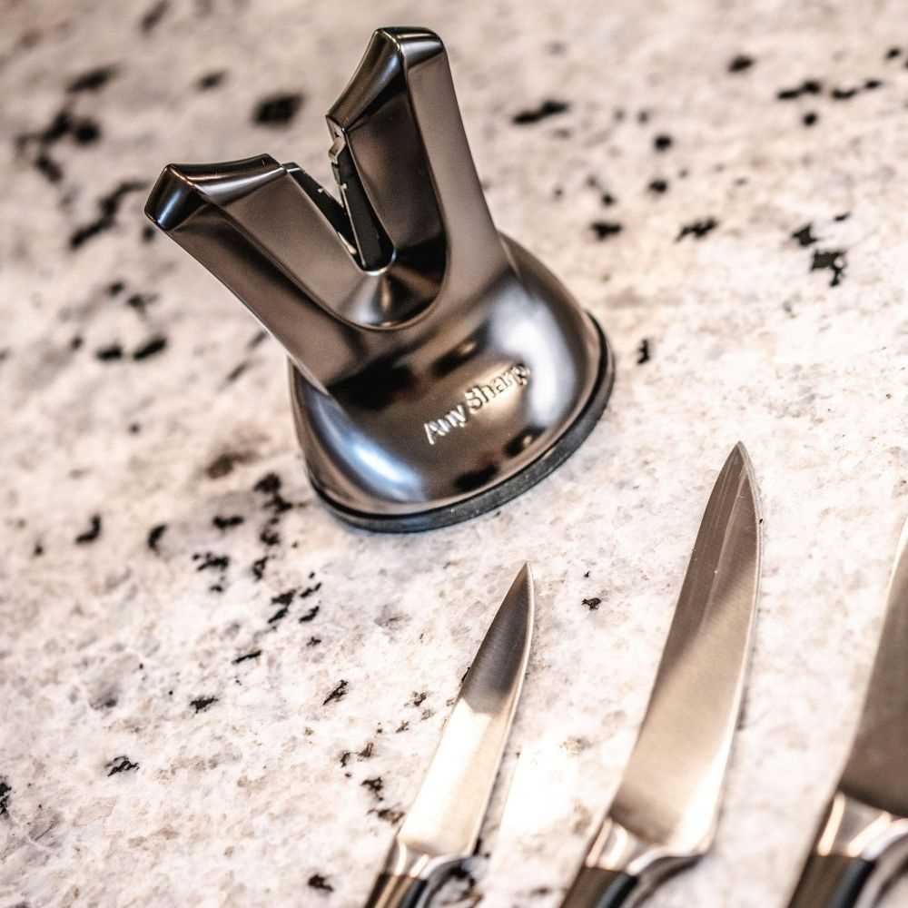 Knife sharpener with two knives on a speckled countertop