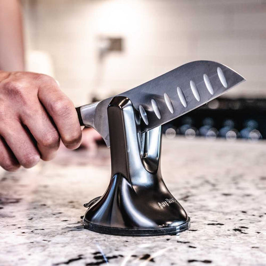 A black, professional knife sharpener with a suction cup base and a metallic blade.