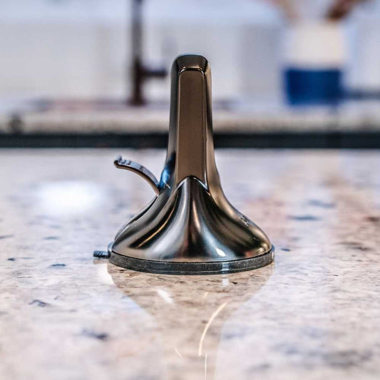 A black, professional knife sharpener with a suction cup base and a metallic blade.