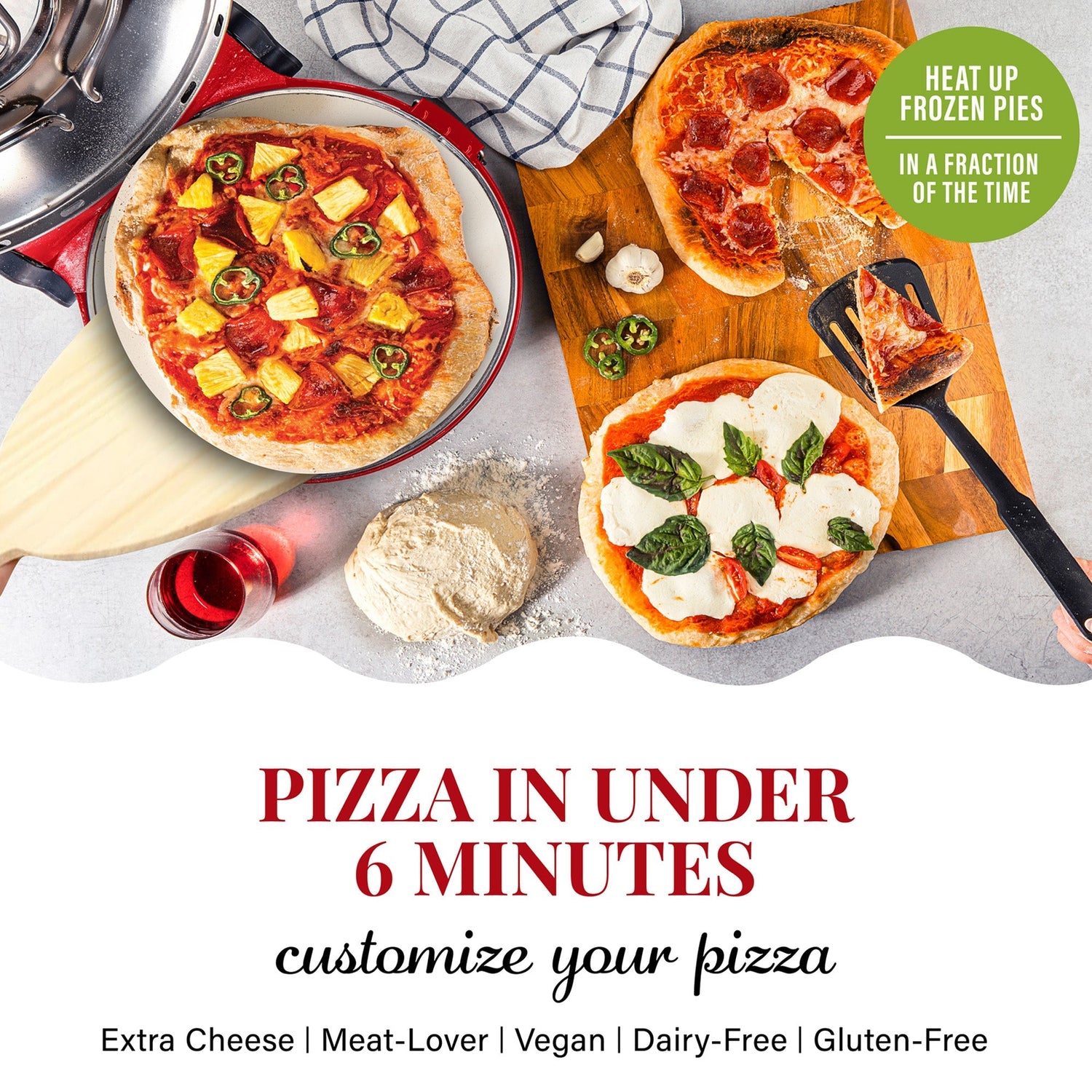 Three pizzas on a table with various toppings, including a spatula and a bottle of red wine.