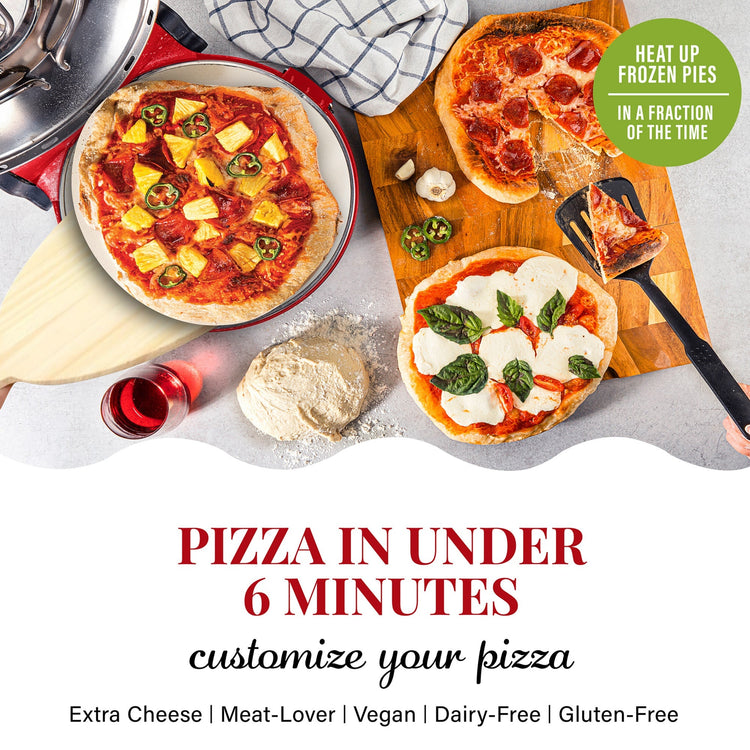 Three pizzas on a table with various toppings, including a spatula and a bottle of red wine.