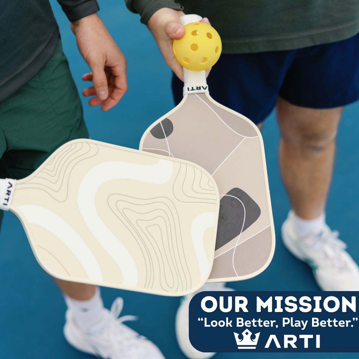 Two pickleball paddles held by a person on a blue court with 'ARTI' branding.