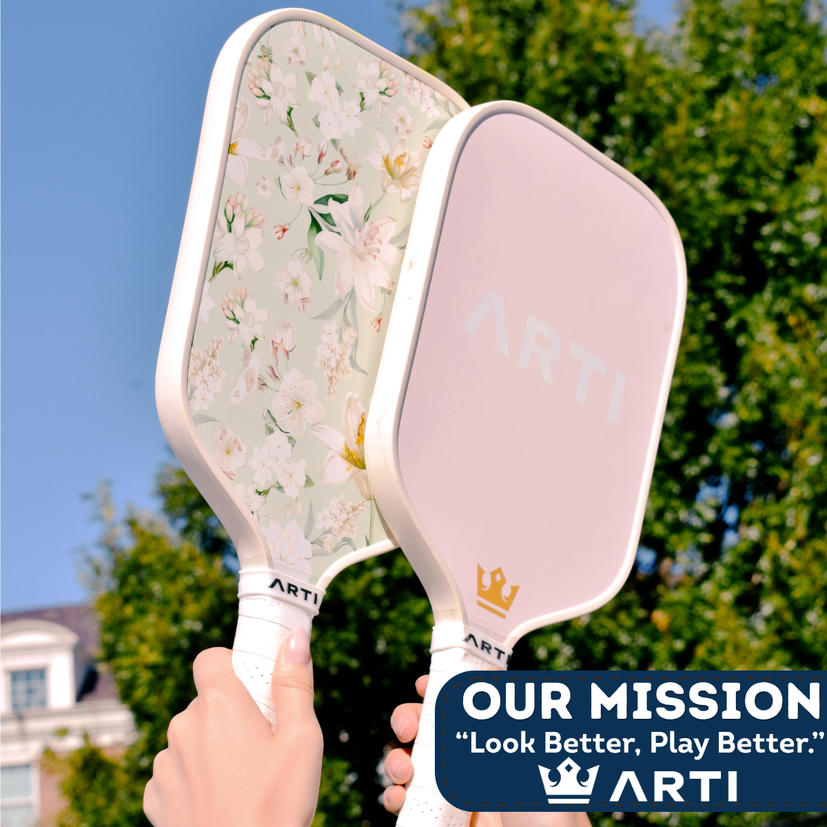 Two paddle sports paddles held by a hand with a blue sky and green trees in the background, featuring the ARTI brand.