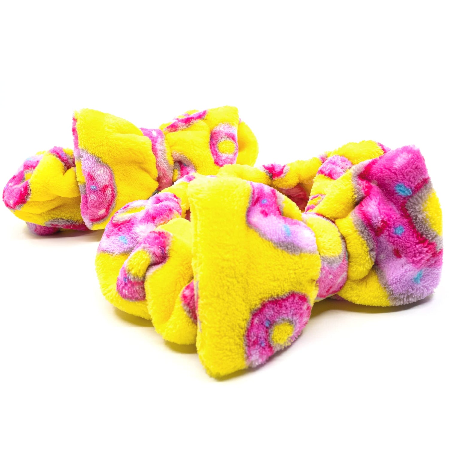 Yellow and pink fleece dog toys on a white background