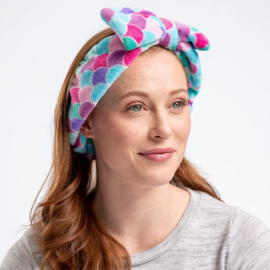 Woman wearing a colorful patterned headband against a plain background