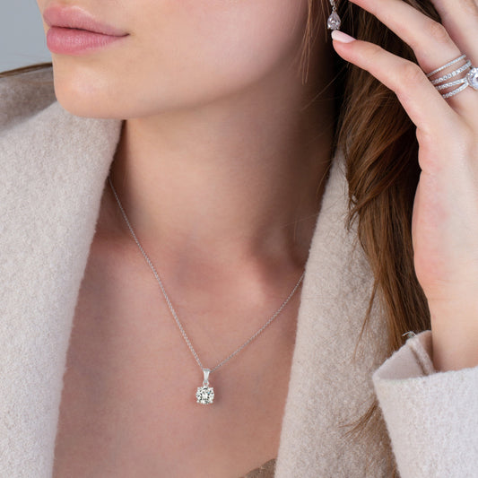 Silver necklace with a round diamond pendant on a white background