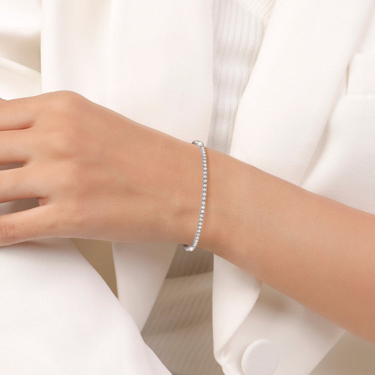 Silver bracelet on a person's wrist with a white background