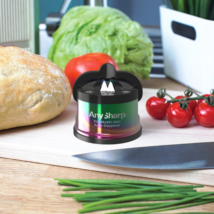 AnySharp knife sharpener on a cutting board with vegetables and bread in the background