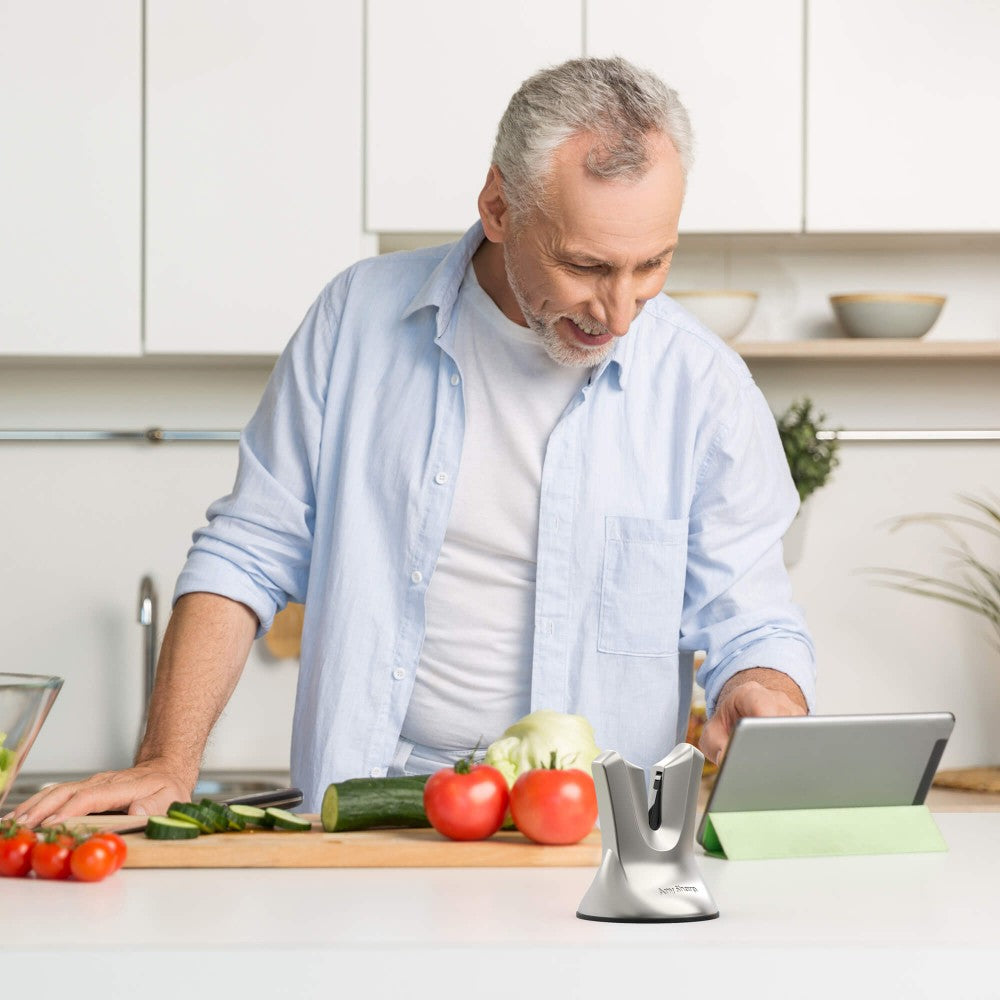 Man using a tablet in a kitchen with vegetables on the counter