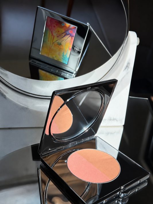 Makeup compact with blush on a reflective surface