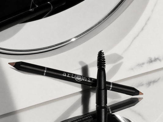 Two makeup pencils with 'artdeco' branding on a reflective surface.