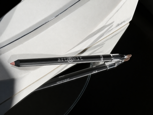 Two artisit makeup pencils on a white surface with a black background