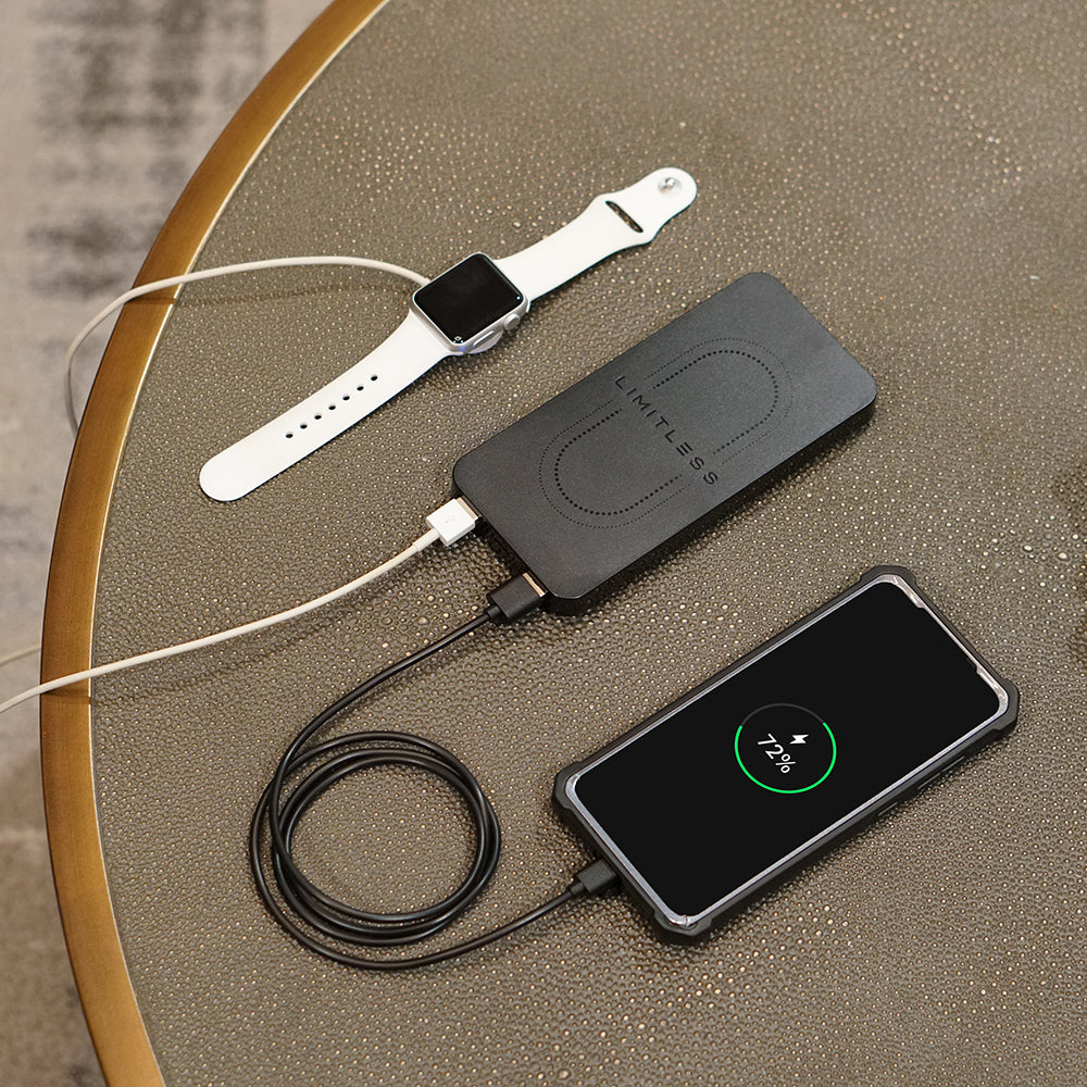 Smartwatch, phone, and wireless charging pad on a textured surface