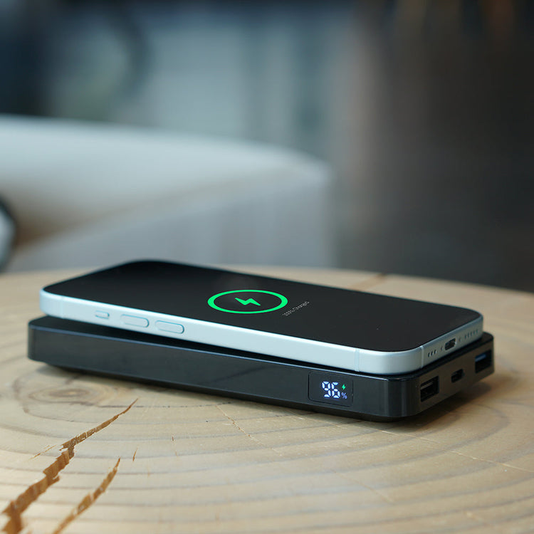 Wireless charging pad with smartphone on a wooden surface