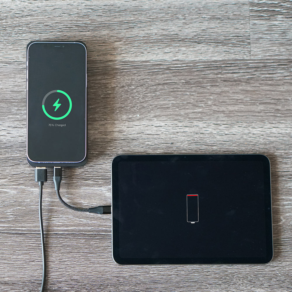 Phone charging on a wooden surface with a tablet nearby