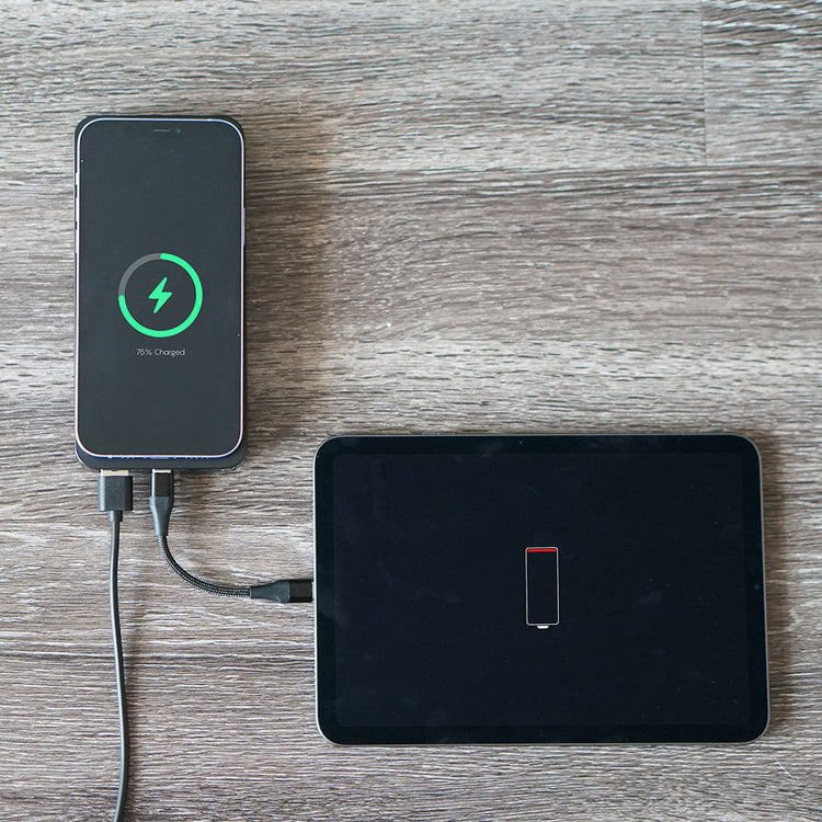 Phone charging on a wooden surface with a tablet nearby